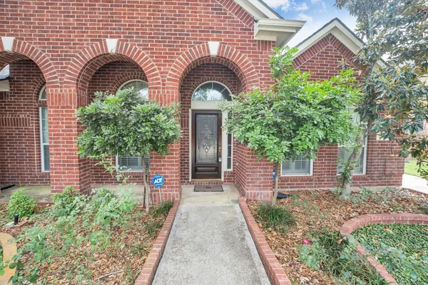 a front view of a house with a tree