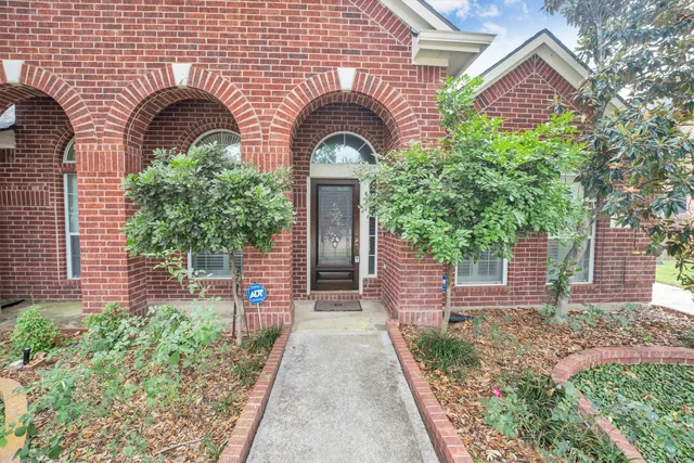 a front view of a house with a tree