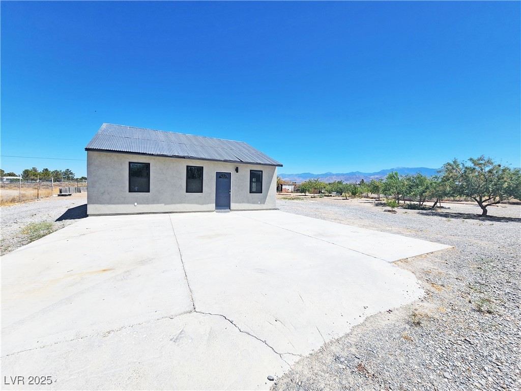 Rear view of property featuring stucco siding, a mountain view, and a metal roof
