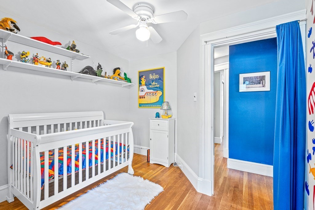 11 Ronald Road Arlington, MA 02474 - Photo 28 of 42 a bedroom with baby crib and wooden floor