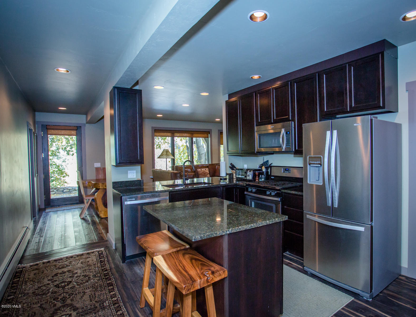 850 Main Street, Unit A Minturn, CO 81645 - Photo 24 of 34 a kitchen with granite countertop kitchen island stainless steel appliances a refrigerator a stove a sink cabinets and a dining table