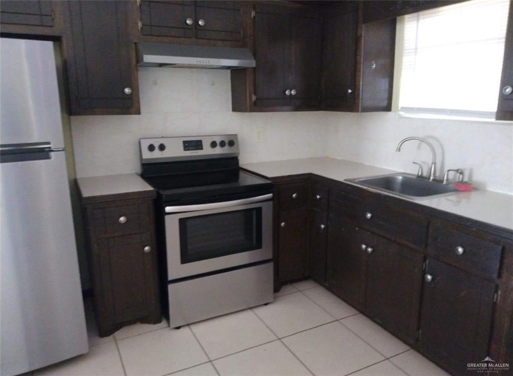 5497 East Guerra Street Rio Grande City, TX 78582 - Photo 7 of 13 a kitchen with a stove and a refrigerator