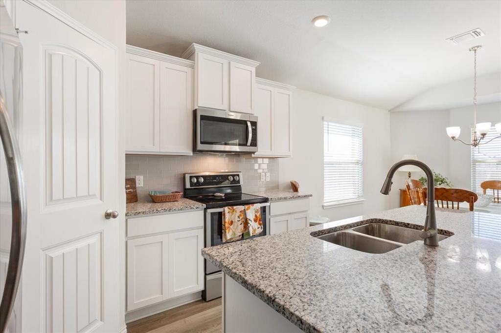11204 Echo Drive Waco, TX 76708 - Photo 11 of 27 a kitchen with stainless steel appliances granite countertop a sink a stove and a refrigerator