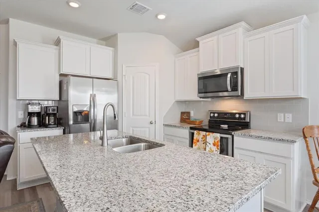 a kitchen with stainless steel appliances wooden cabinets and granite counter tops