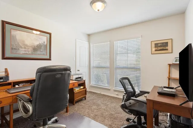 a view of a workspace with furniture and a window