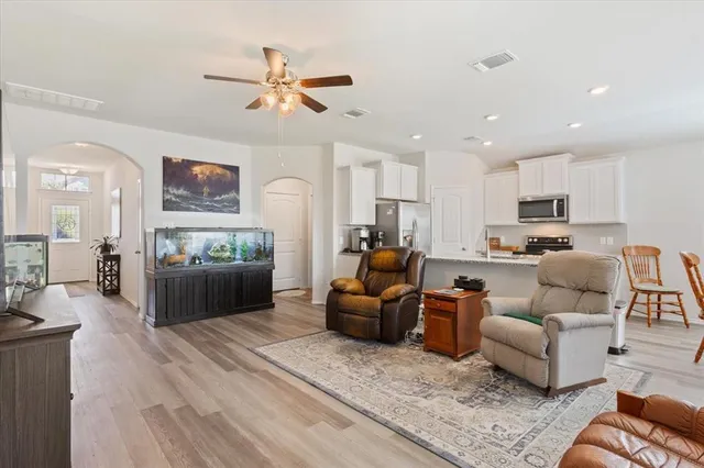 a living room with furniture kitchen area and a window