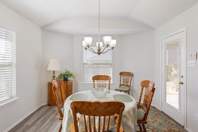 a dining room with furniture a potted plant and wooden floor