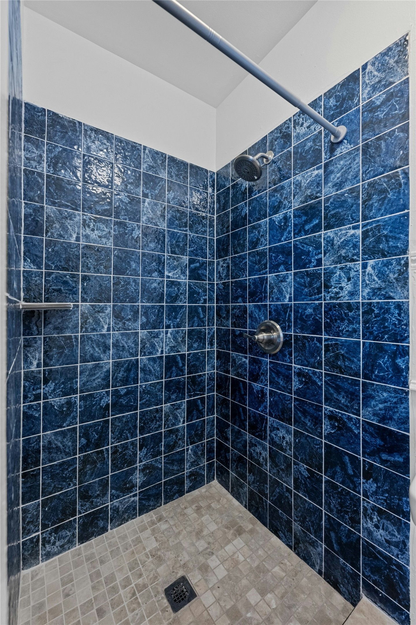 2201 Leon Street, Unit G Austin, TX 78705 - Photo 12 of 17 Shower stall featuring dark blue wall tiling with a variegated pattern and light-toned square floor tiling