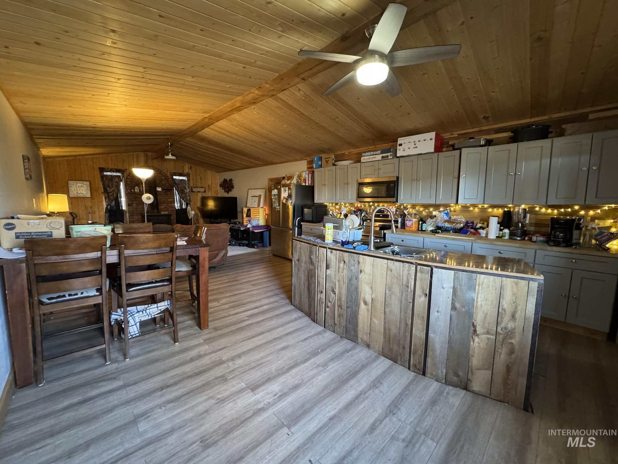 40238 Sr 129 Anatone, WA 99401 - Photo 3 of 13 Kitchen featuring a ceiling fan, stainless steel appliances, wooden ceiling, light wood-type flooring, and wooden walls