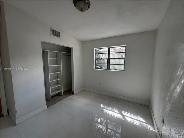 an empty room with windows and closet