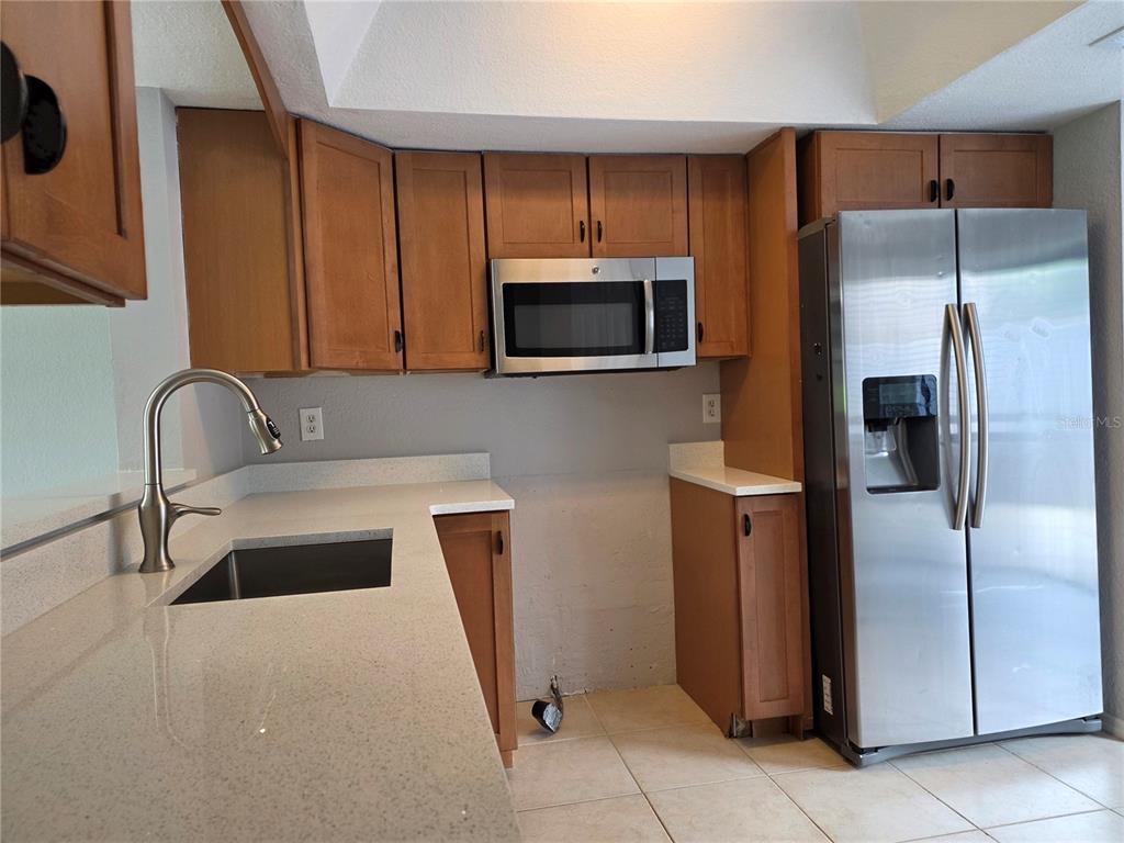 162 Olive Tree Circle Altamonte Springs, FL 32714 - Photo 9 of 47 a kitchen with granite countertop a refrigerator and a stove top oven