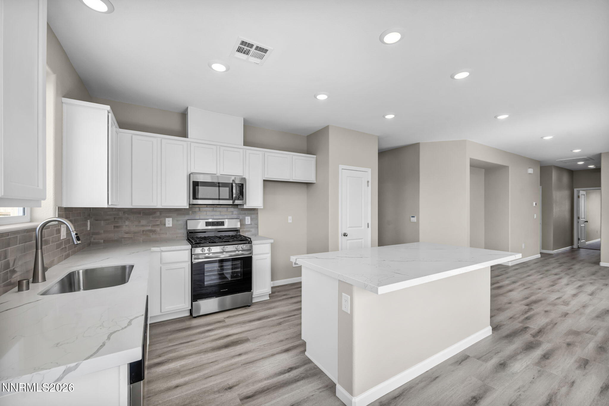 6668 Morgan Mill Road, Unit HOMESITE 15 Carson City, NV 89701 - Photo 2 of 25 a large kitchen with stainless steel appliances a large counter top a stove and a sink
