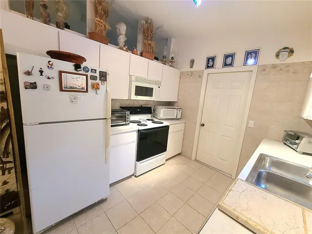 a kitchen with stainless steel appliances a refrigerator sink and microwave