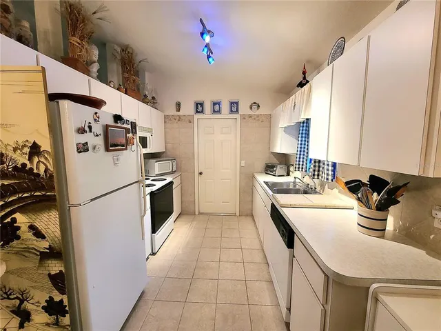 a kitchen with a sink a refrigerator and cabinets