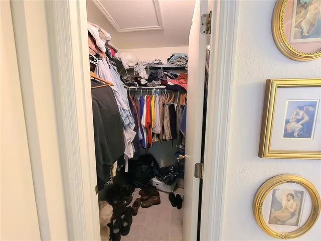 a view of walk in closet with clothes and shoes