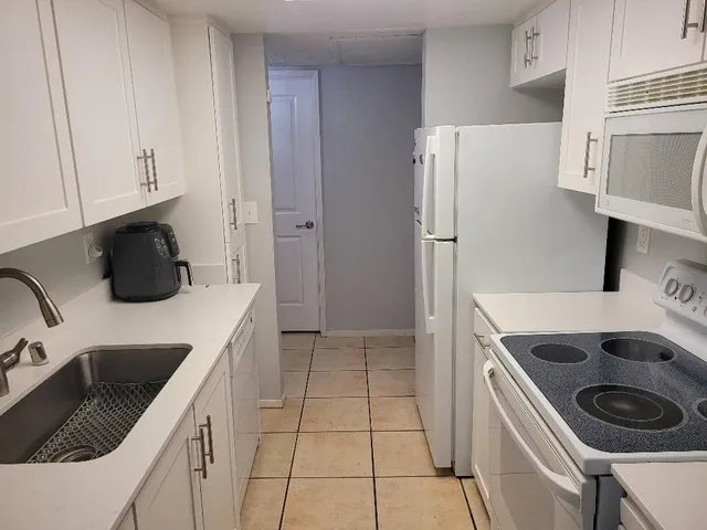 a kitchen with a refrigerator and a sink
