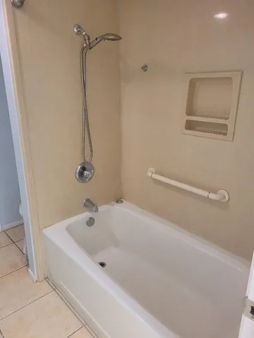 a white bath tub sitting next to a shower