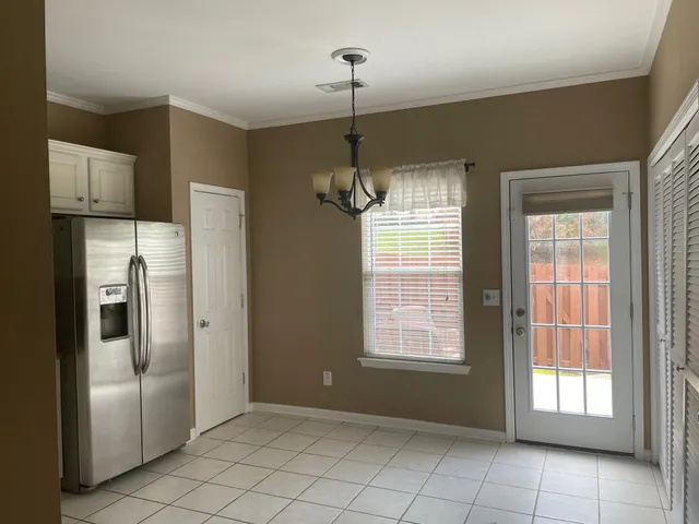 a empty room with windows and refrigerator