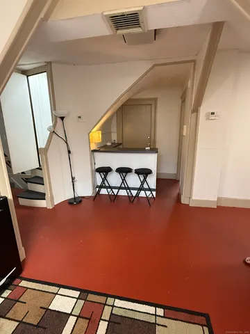 a bedroom with a bed and dresser with wooden floor