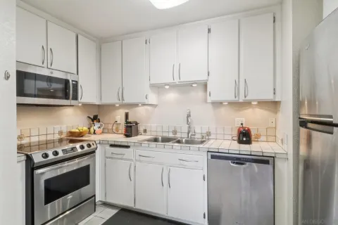 a kitchen with stainless steel appliances granite countertop a sink a stove a microwave and cabinets