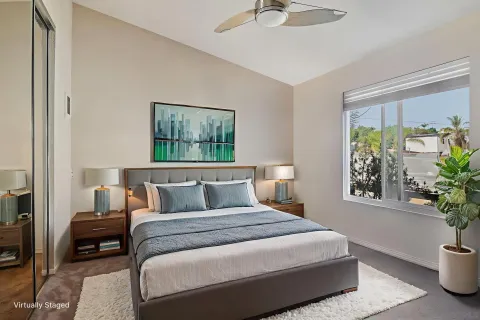a bedroom with a large bed and a potted plant