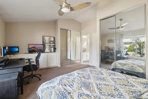 a bedroom with a bed and a desk in it with window