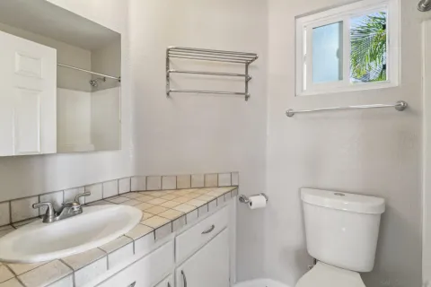 a bathroom with a granite countertop toilet sink and mirror