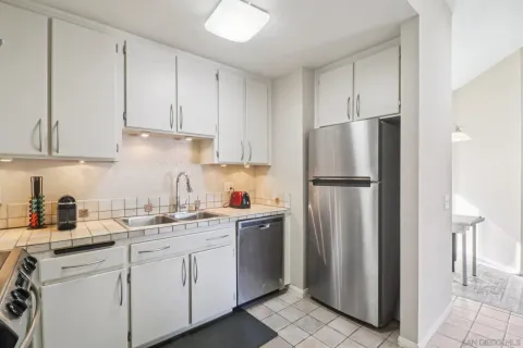 a kitchen with white cabinets and refrigerator