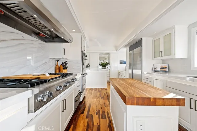 a open kitchen with white cabinets and stainless steel appliances