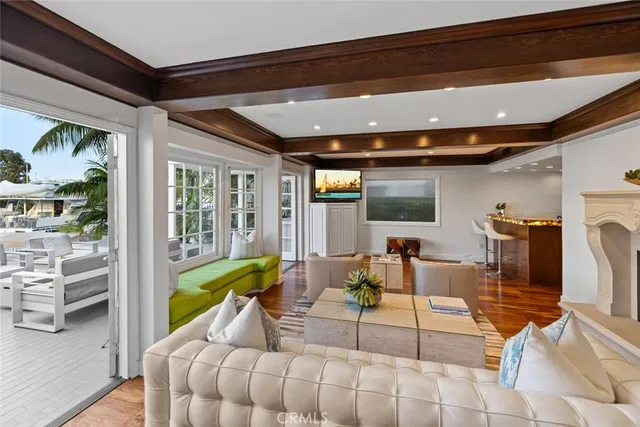 a living room with furniture a fireplace and a dining table with wooden floor