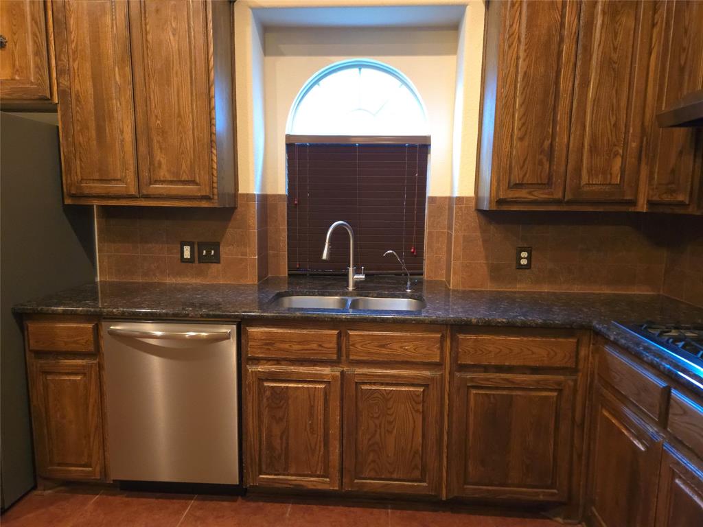 9316 Turtle Pass Fort Worth, TX 76177 - Photo 13 of 38 a kitchen with granite countertop a sink stainless steel appliances and cabinets