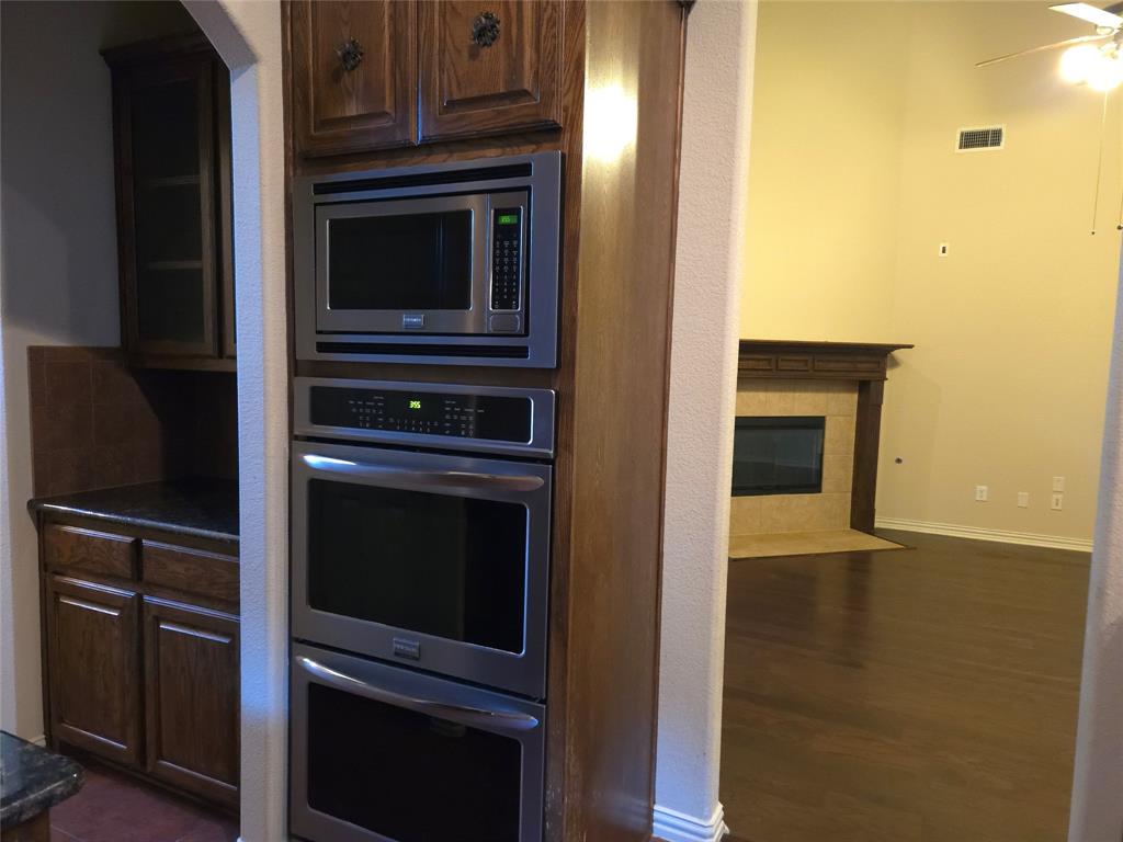 9316 Turtle Pass Fort Worth, TX 76177 - Photo 15 of 38 a kitchen with granite countertop cabinets stainless steel appliances and wooden floor