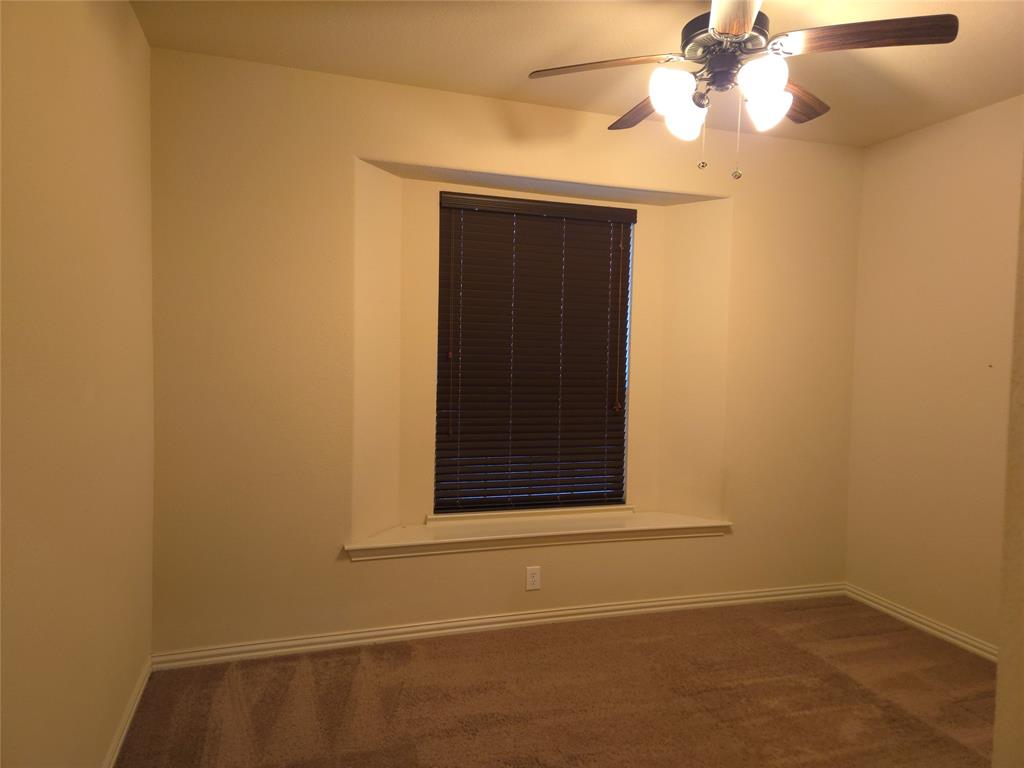 9316 Turtle Pass Fort Worth, TX 76177 - Photo 6 of 38 an empty room with a window and a ceiling fan
