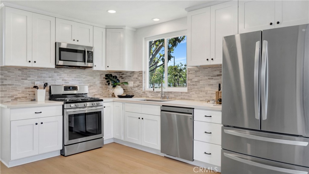 336 Fallingstar Irvine, CA 92614 - Photo 21 of 73 a kitchen with stainless steel appliances white cabinets white stove a sink and a refrigerator