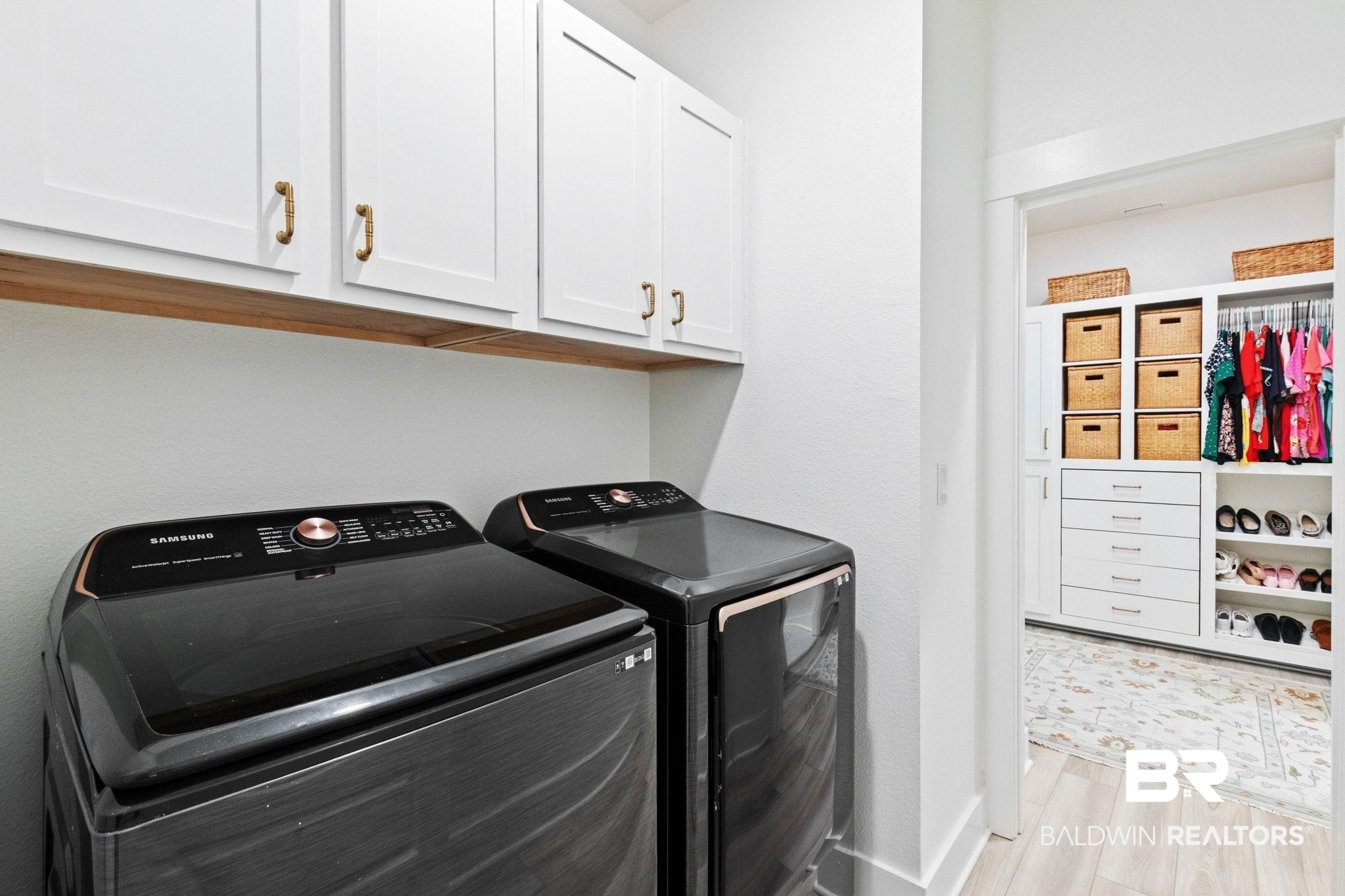 9815 Lakeview Drive Foley, AL 36535 - Photo 54 of 100 Clothes washing area with cabinets, light hardwood / wood-style flooring, and washer and clothes dryer