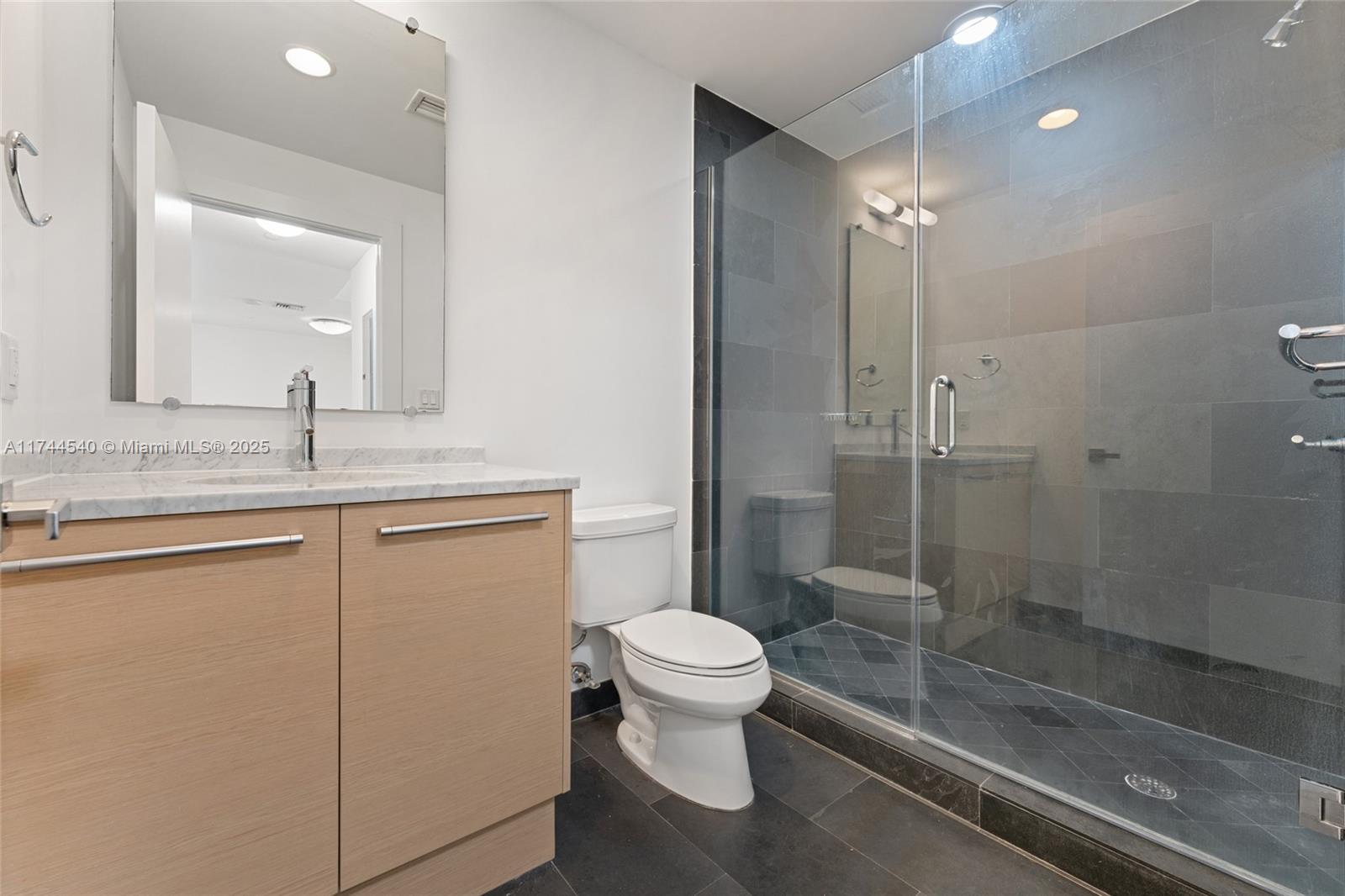 900 Biscayne Boulevard, Unit 4708 Miami, FL 33132 - Photo 18 of 39 a bathroom with a granite countertop sink mirror toilet and shower