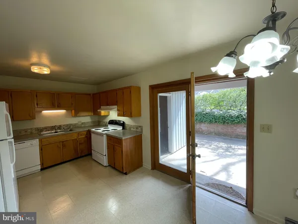 a large kitchen with granite countertop a stove a sink a refrigerator and a dining table