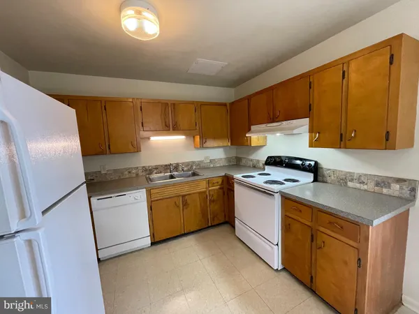 a kitchen with granite countertop a sink stove and refrigerator