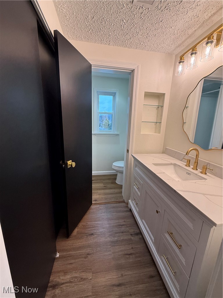 522 North 3rd Street Toronto, OH 43964 - Photo 24 of 47 Bathroom with vanity, dark wood-style flooring, and a textured ceiling