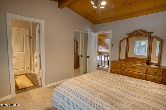 a bedroom with a bed and a large mirror on the dresser