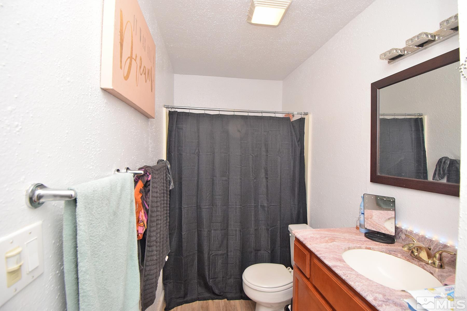 4608 Neil Road, Unit 263 Reno, NV 89502 - Photo 11 of 16 a bathroom with a sink a toilet and shower curtain