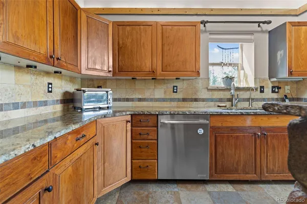 a kitchen with stainless steel appliances granite countertop a sink a stove and cabinets