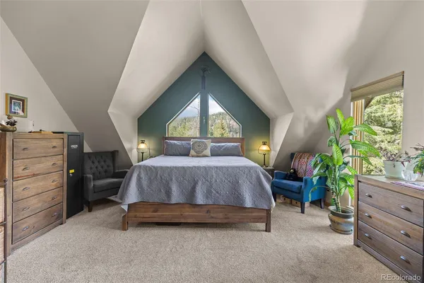 a spacious bedroom with a bed and a potted plant