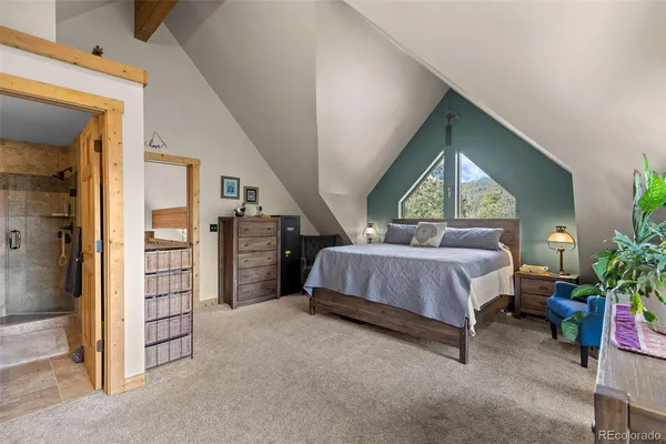 a spacious bedroom with a bed a potted plant and a large window