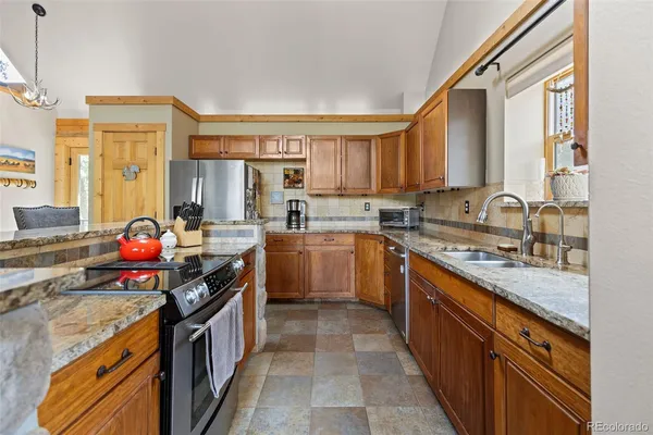 a kitchen with stainless steel appliances a sink stove top oven and cabinets