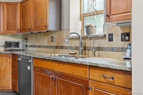 a kitchen with granite countertop stainless steel appliances a sink and cabinets