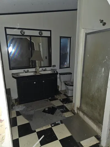 a living room with a black white checkered floor with a gaming machine and appliances