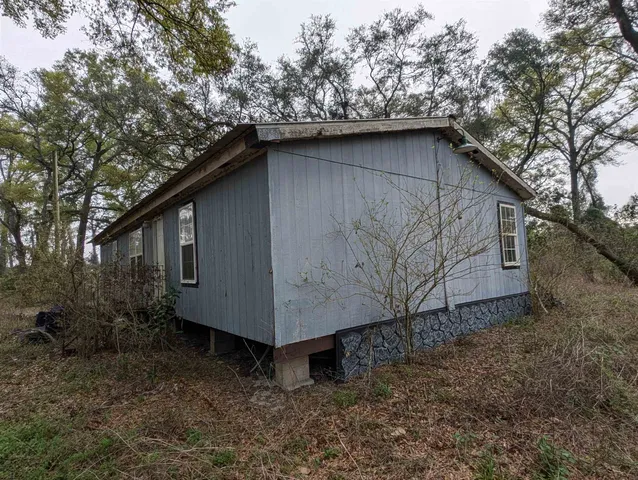 a wooden house with a yard and large trees