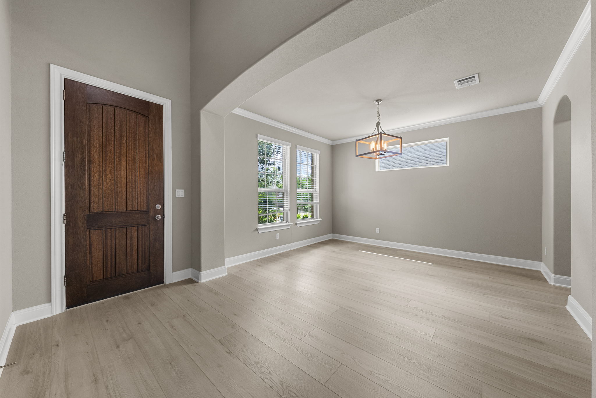 4401 Trinity Woods Street Leander, TX 78641 - Photo 3 of 37 Enter into a bright, open living space, featuring elegant crown molding and light wood flooring.