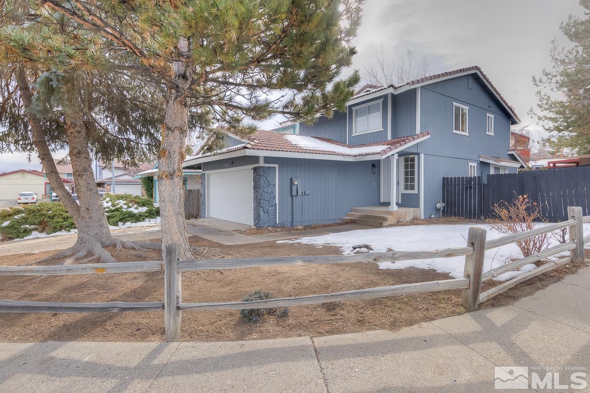 7196 Indigo Circle Reno, NV 89506 - Photo 2 of 33 a view of a white house with large tree and wooden fence